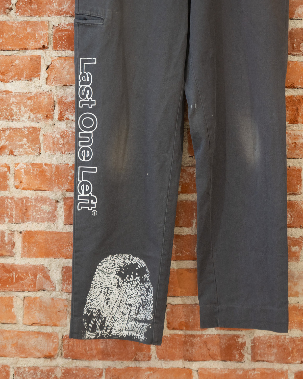 Black vintage pants with multicolored screenprinted designs on them.