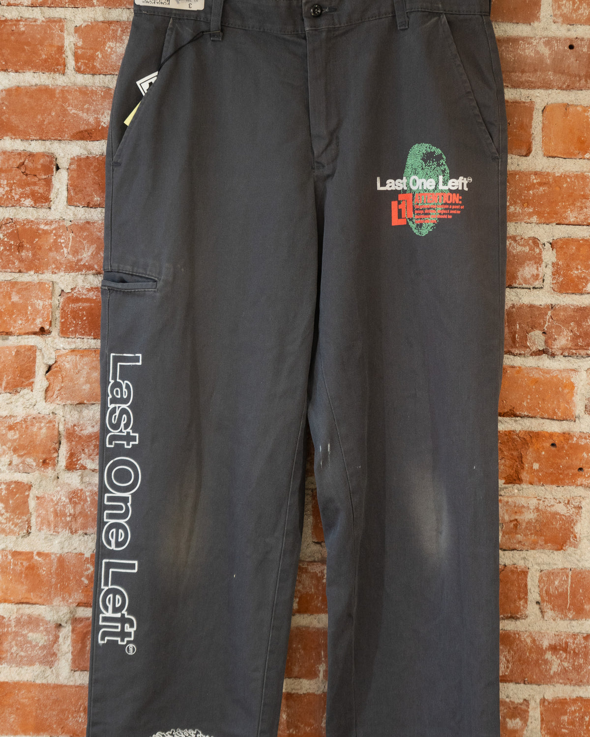 Black vintage pants with multicolored screenprinted designs on them.