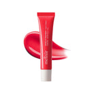 A red squeeze tube of melixir Vegan Lip Treatment with a white cap, shown against a white background with a glossy red product smear behind it.