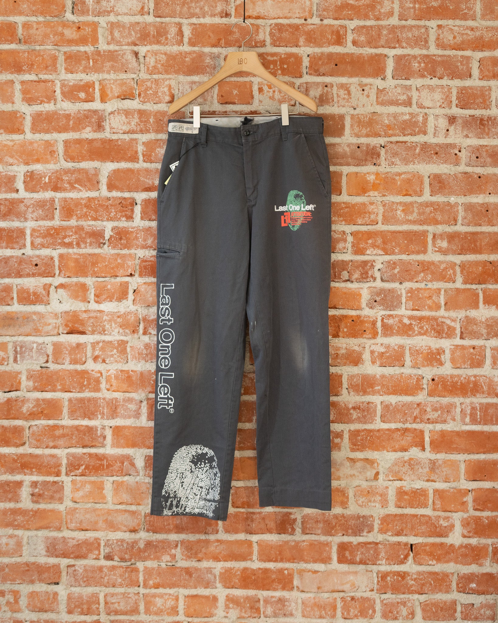 Black vintage pants with multicolored screenprinted designs on them.
