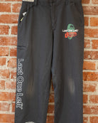 Black vintage pants with multicolored screenprinted designs on them.