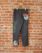 Black vintage pants with multicolored screenprinted designs on them.