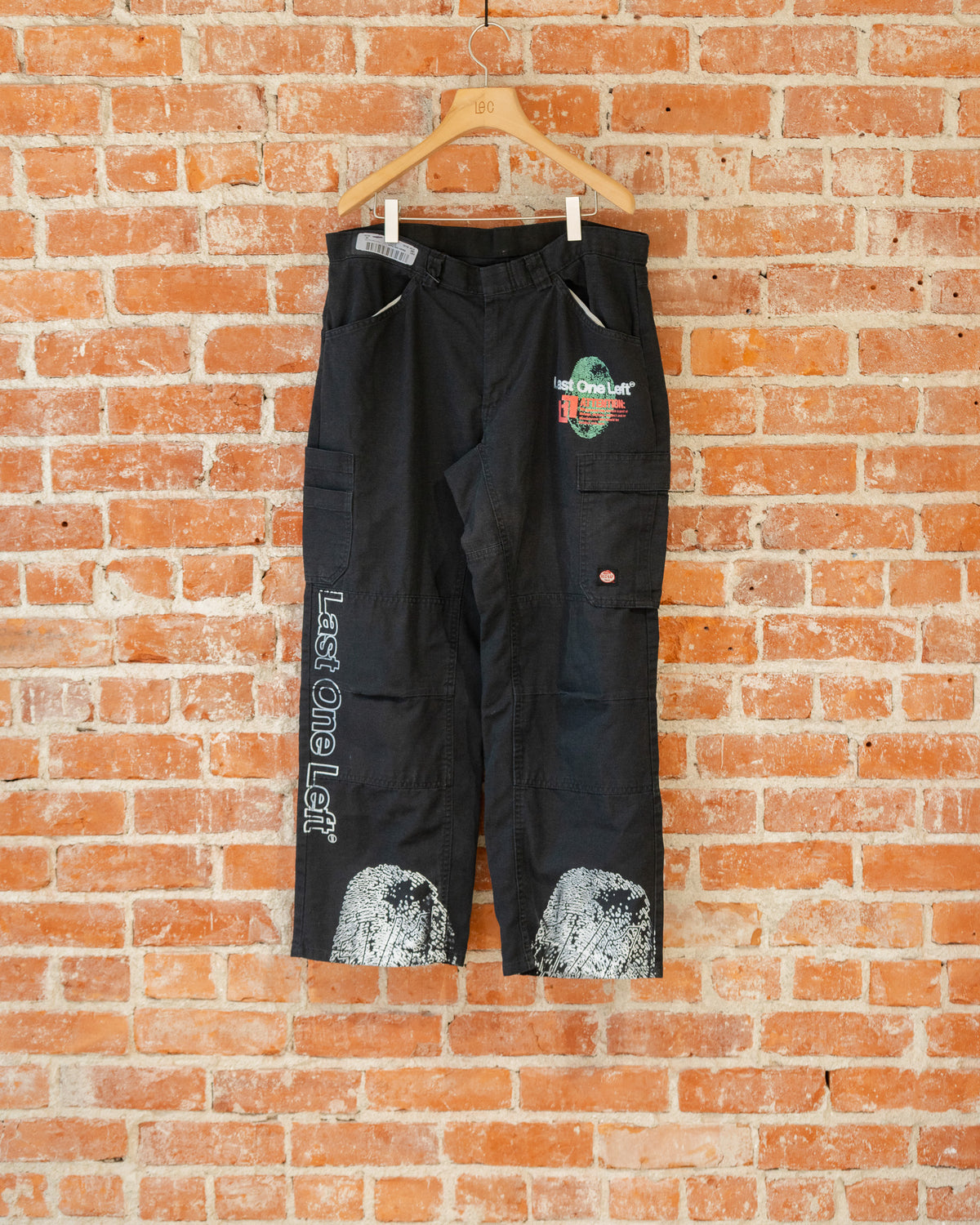 Black vintage pants with multicolored screenprinted designs on them.