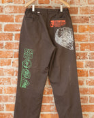 Brown vintage pants with multicolored screenprinted designs on them.