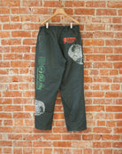 Green vintage pants with multicolored screenprinted designs on them.